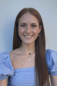 Dark haired woman in light blue blouse.