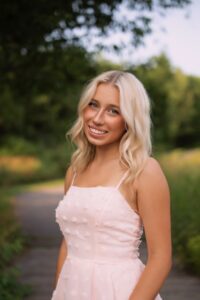 Blonde woman in pink dress in a meadow